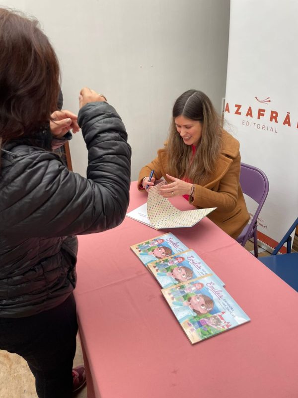 Foto de la autora, Constanza Marín, firmando copias del libro.