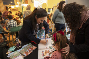 Dra. Clau Morales firmando libros en el lanzamiento de ¡Chao, chupete!